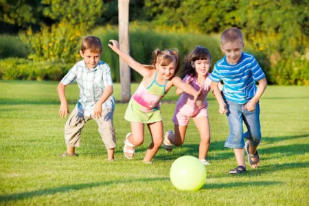 4 children playing with a ball outside